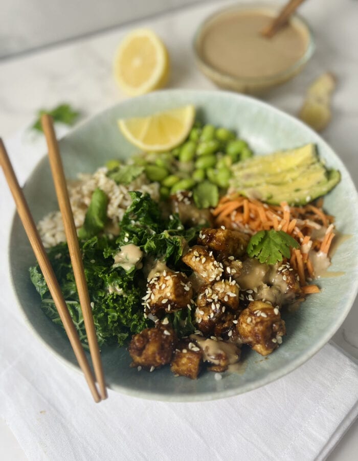 close up of crispy asian tofu bowl with chopsticks