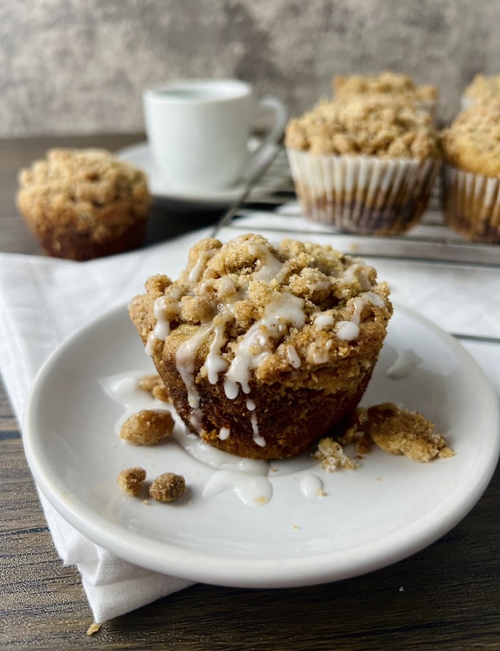 A picture of a vegan coffee cake muffin with an icing dripping off the top 