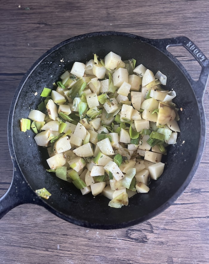 This is a picture of leeks and potatoes in a pot. 