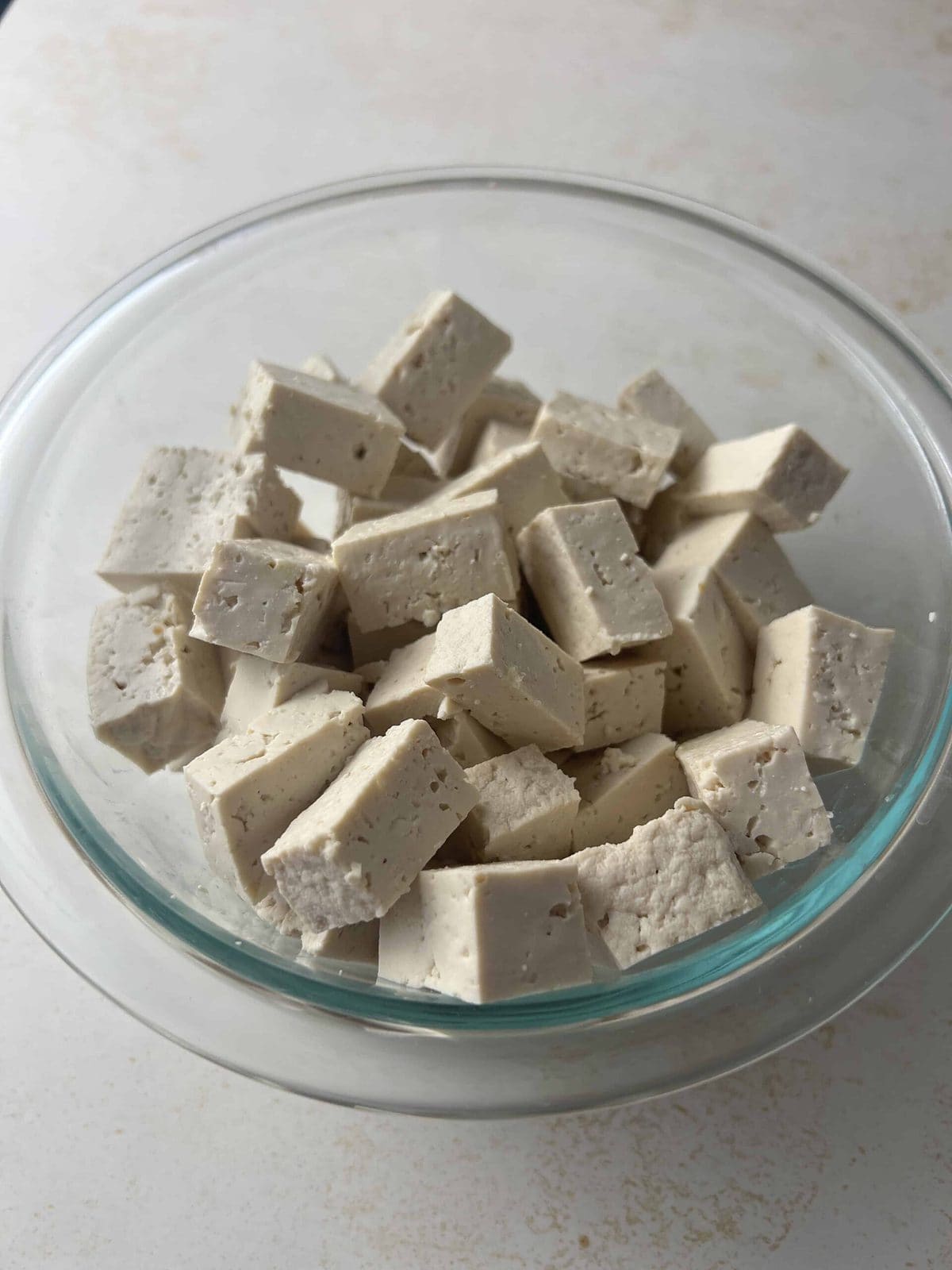 This is a photo of cut up tofu in a bowl.
