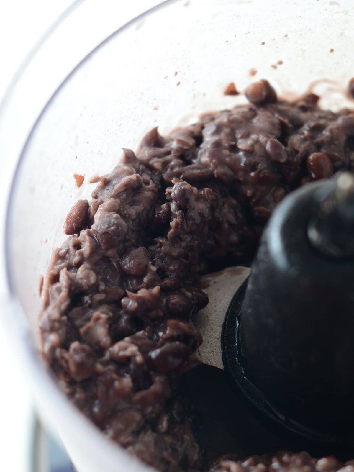 This is a photo of black beans in a food processor.