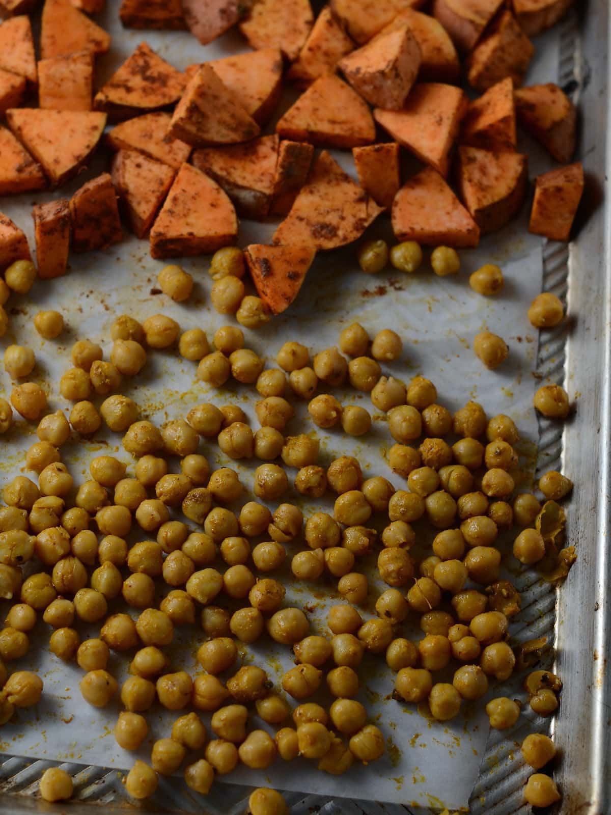 This is a photo of pre-cooked sweet potatoes and chickpeas on a pan.