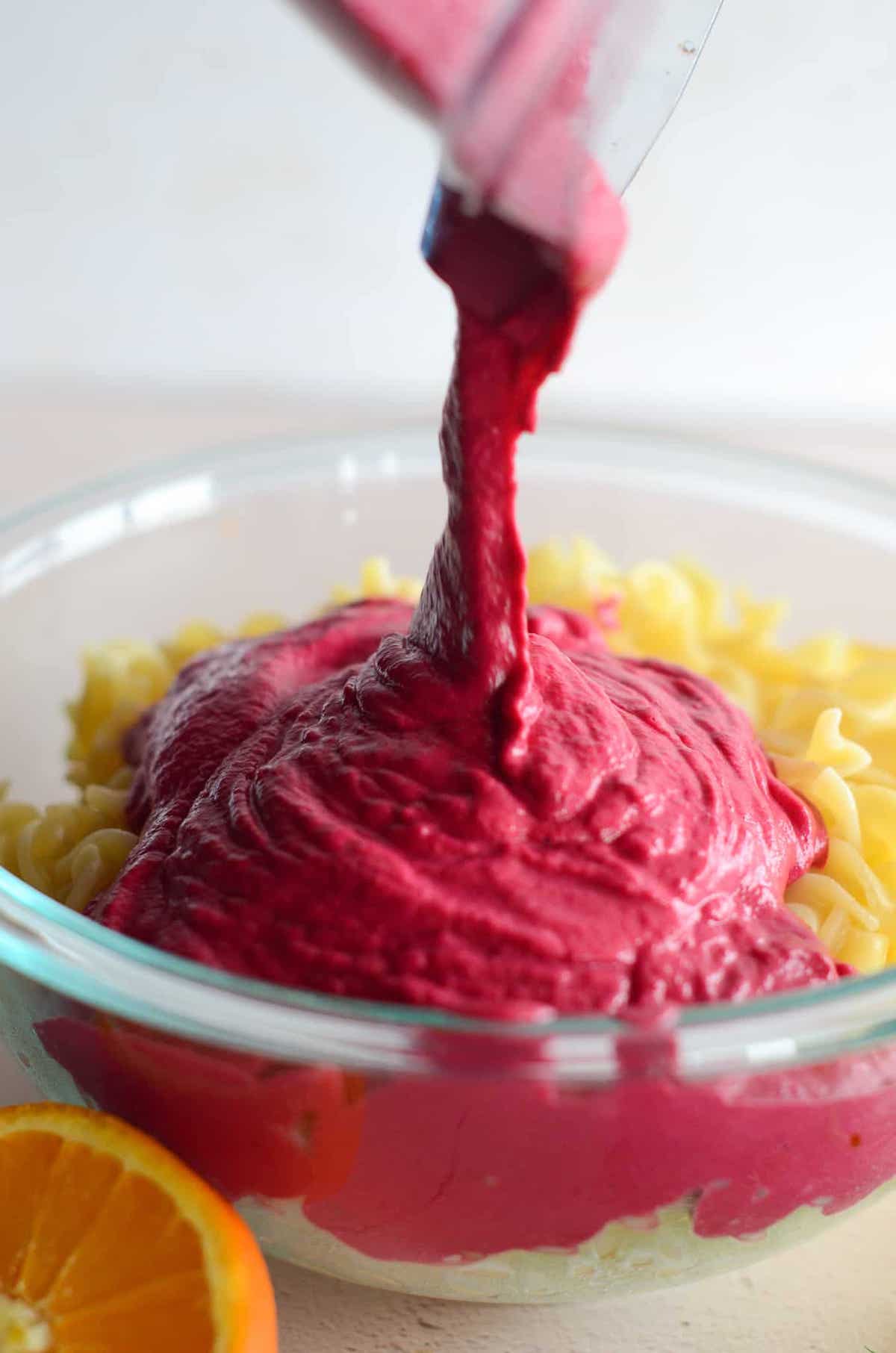 This is a photo of the beet sauce pouring over noodles.