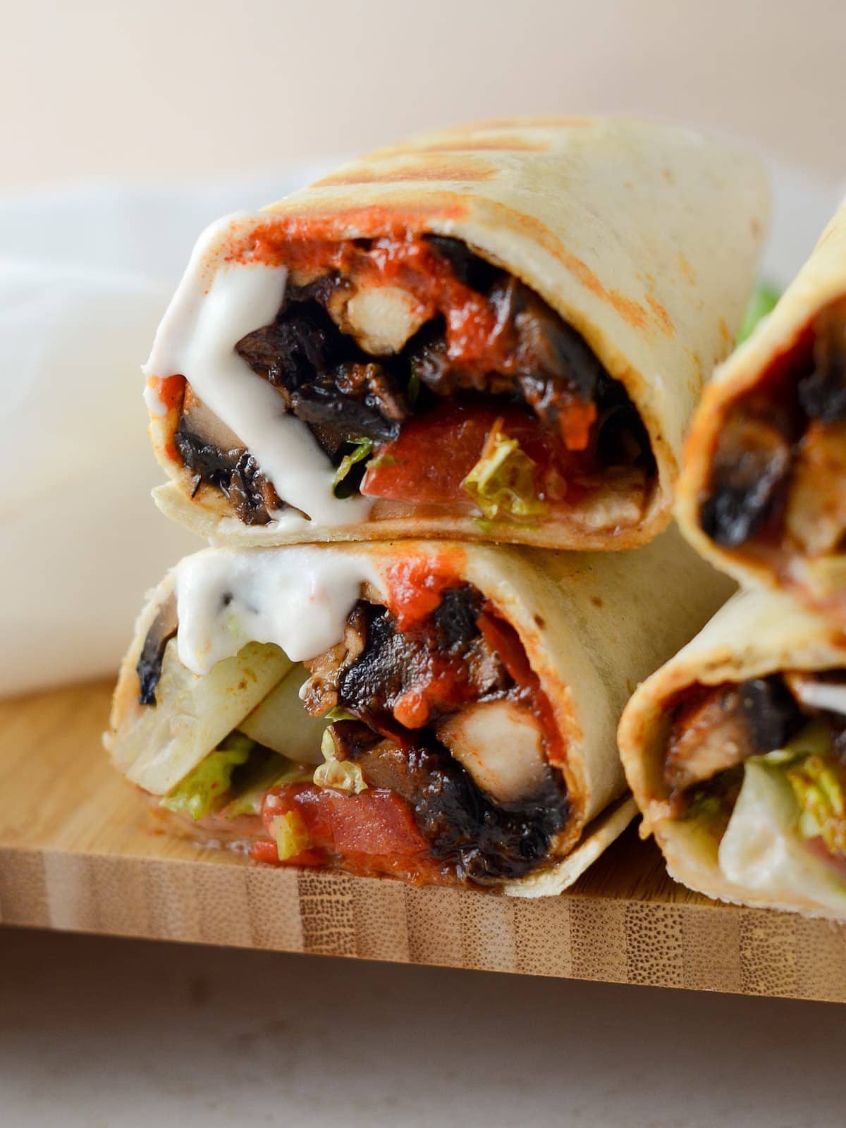 This is a photo of the portobella mushroom wrap close up with the yogurt sauce and harissa.