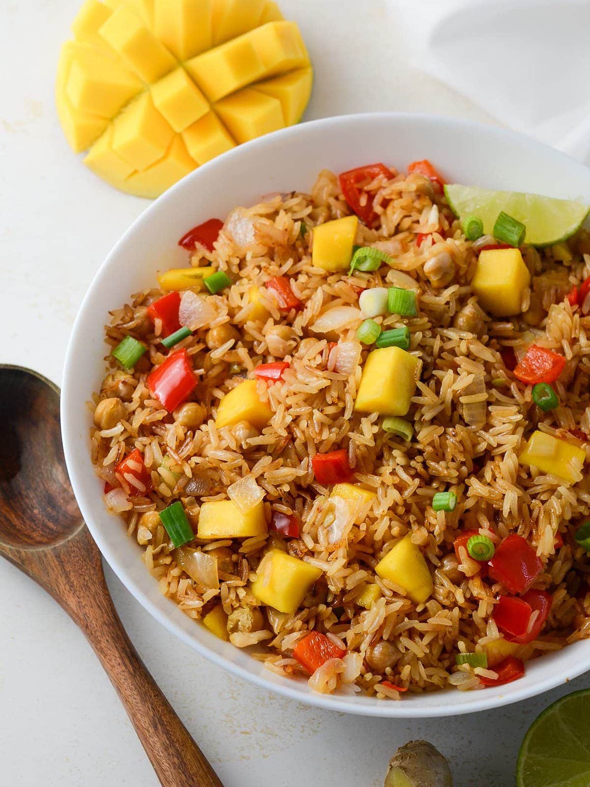 This is a photo of an overhead shot of mango fried rice with a mango in the background.