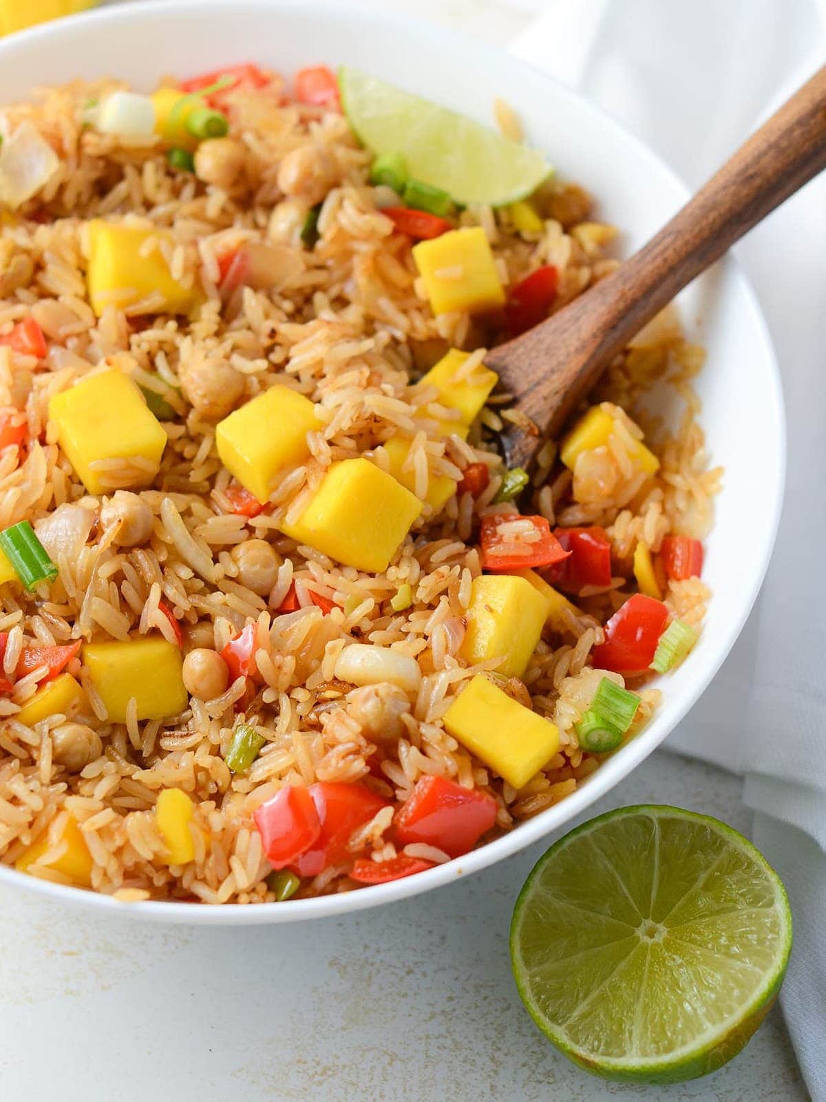 This is a photo of mango fried rice with a spoon in it.
