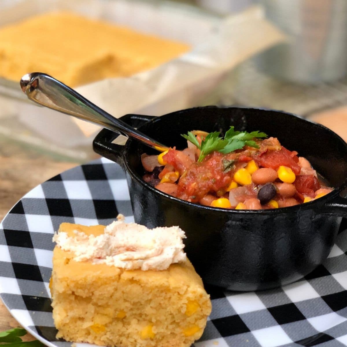 bowl of vegan chili in a black bowl with cornbread.