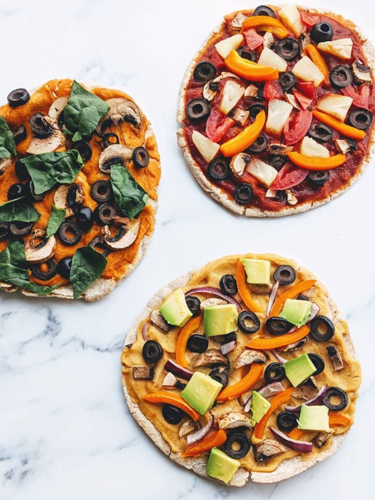 3 pita pizzas on a table. 