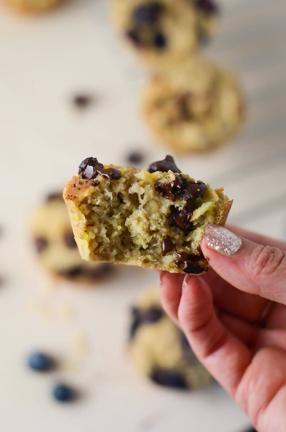 This is a photo of a hand holding a half of a muffin.