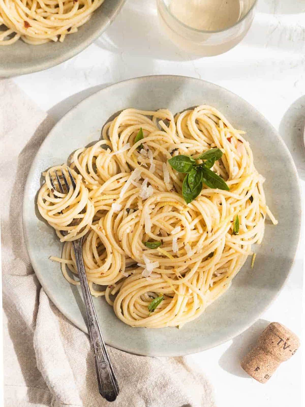 lemon garlic pasta on a plate with a fork. 
