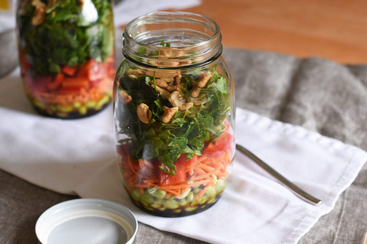 a salad in a jar, lid off, with fork on the side.
