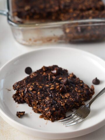 Photo of vegan brownie baked oatmeal slice on a plate.