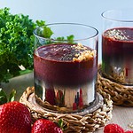 kale beet smoothie in a glass with strawberries and mixed berries