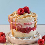 blended overnight oats in a jar with drizzled peanut butter and raspberry