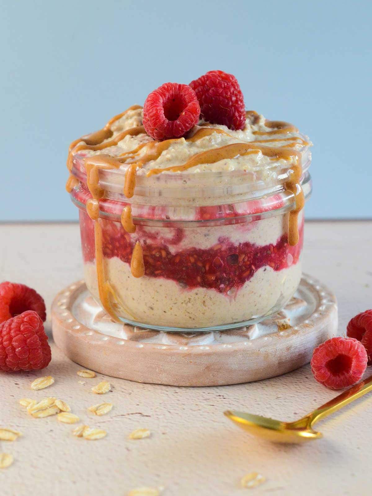 blended overnight oats in a jar with drizzled peanut butter and raspberry 
