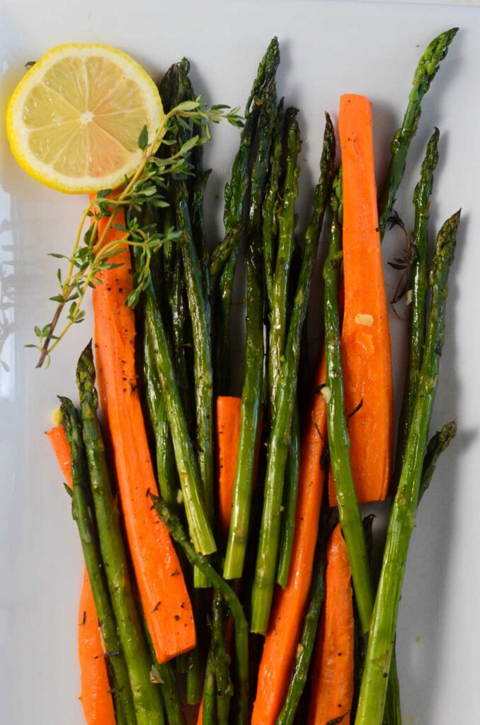 carrots and asparagus roasted with lemon and thyme on a plate.