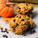a no bake pumpkin cookie laying against another cookie with a pumpkin on the left.