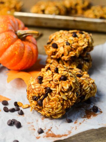 a no bake pumpkin cookie laying against another cookie with a pumpkin on the left.