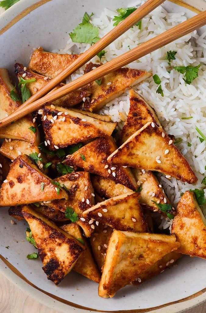 miso glazed tofu in a bowl with chopsticks and rice.